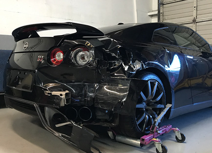 Repairing back of black Nissan